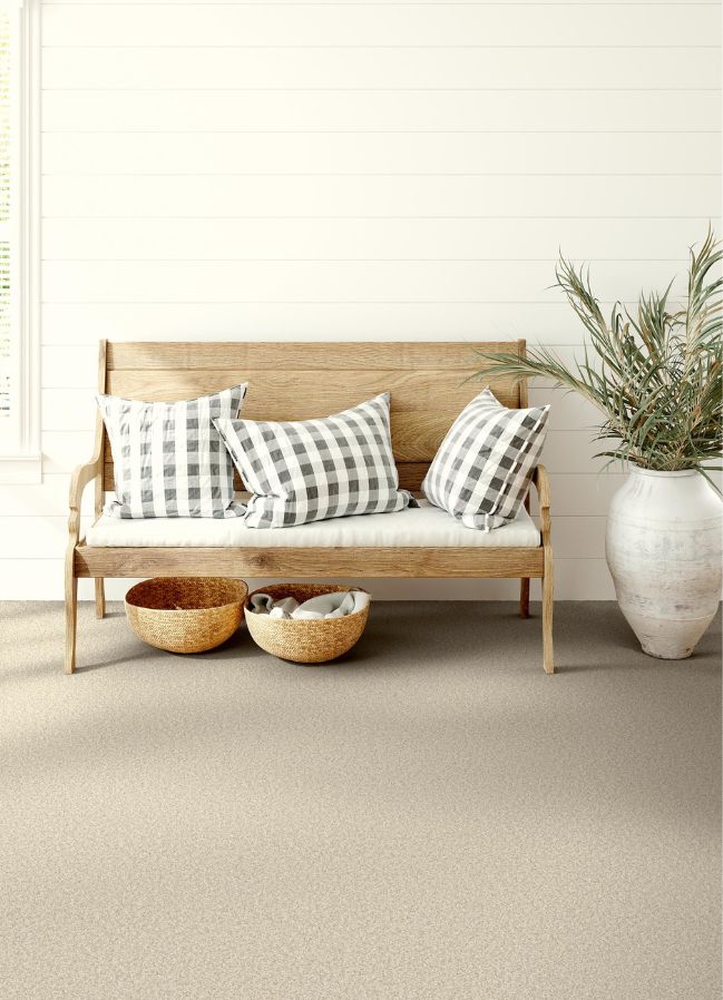 beige carpets in a bright entryway with a bench