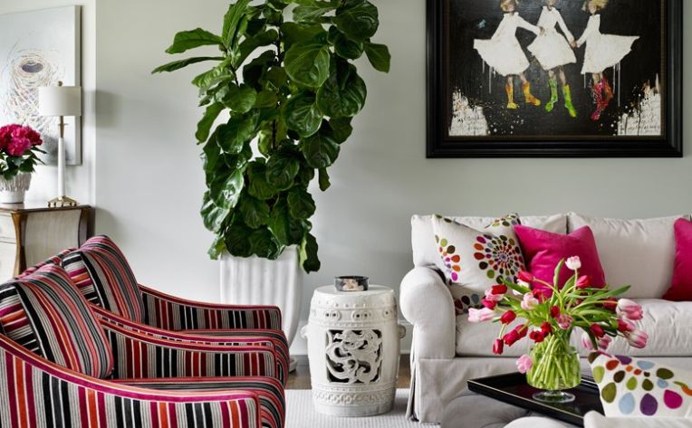 pink accents in living room with striped armchairs